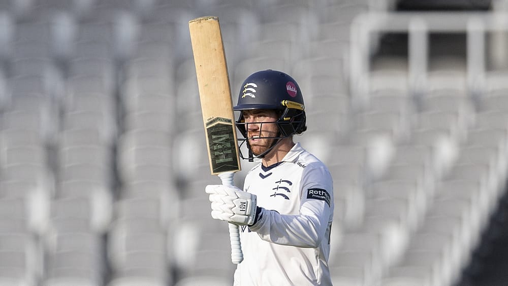 Middlesex's Ryan Higgins raises his bat after reaching a hundred against Northamptonshire at Lord's